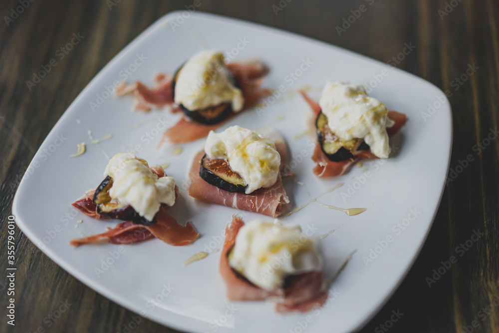 prosciutto, fig, and burrata bites on a plate