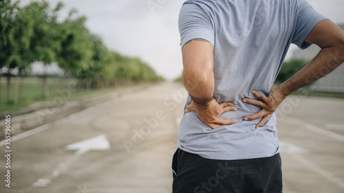 Foto Sport man feeling backache outdoors