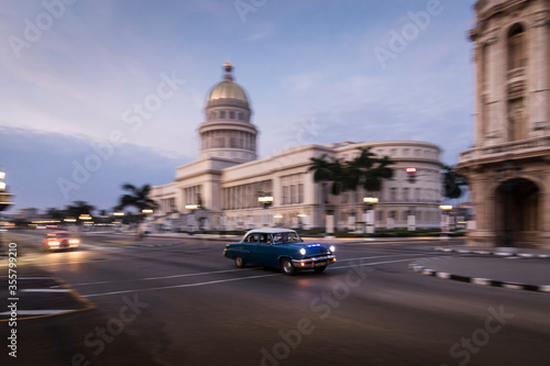 Old car on streets of Havana with Capitolio building in background. Cuba