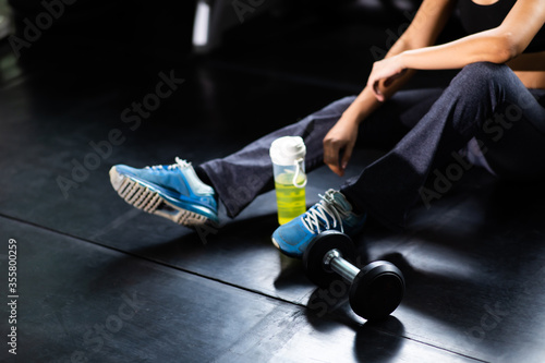 Female athlete taking rest after exercising at gym. Fitness Healthy lifestye and workout at gym concept. photo