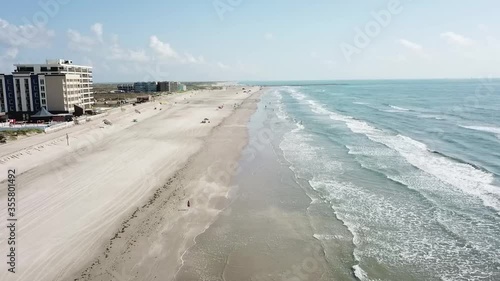 Aerial view moving up the beach and over the surf above Padre Island, Corpus Christi Texas