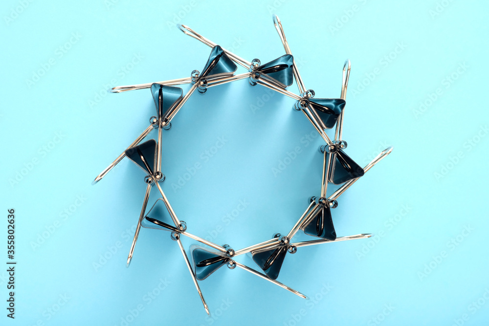 Flying binder clips’ circle on blue background.