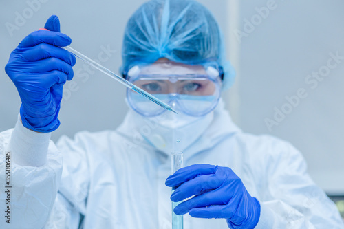Scientist or researcher hand in blue gloves holding flu, measles, coronavirus, covid-19 vaccine disease preparing for human clinical trials vaccination shot, medicine and drug concept.