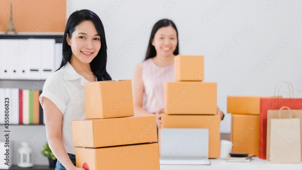Asian beautiful empower woman working with online business shop at home.Owner businesswoman start up with Accept orders,Check number of products,Prepare to deliver products to customers. Asian beautiful empower woman working with online business shop at home.Owner businesswoman start up with Accept orders,Check number of products,Prepare to deliver products to customers.