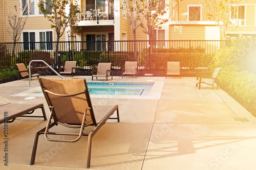 Residential pool with empty sunbed and lounge chairs