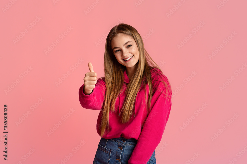 Hand gesture is excellent. Smiling teenager girl showing thumbs up Hand gesture is excellent. Smiling teenager girl showing thumbs up