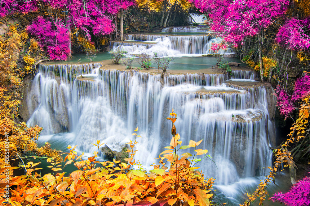 Beauty in nature, beautiful waterfall flowing of water with turquoise color of water in colorful autumn forest at fall season