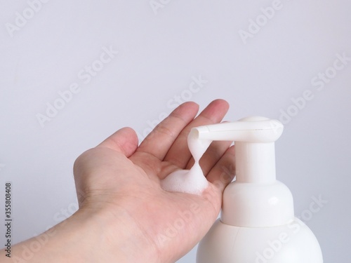 Woman hands pump liquid soap into the palm for washing hands. Personal hygiene for anti-virus and anti-bacteria in cleaning hands concept with white background.