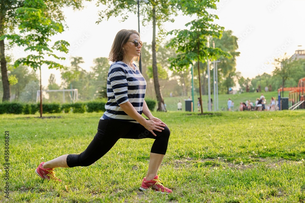 Mature woman doing fitness exercises in park