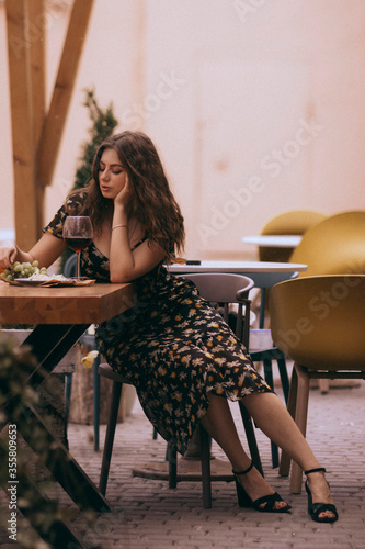 girl sitting in a cafe with a glass of wine