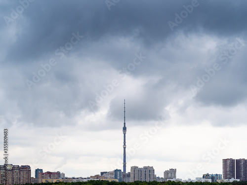 dark rainy clouds over residential district of Moscow city and TV tower in spring