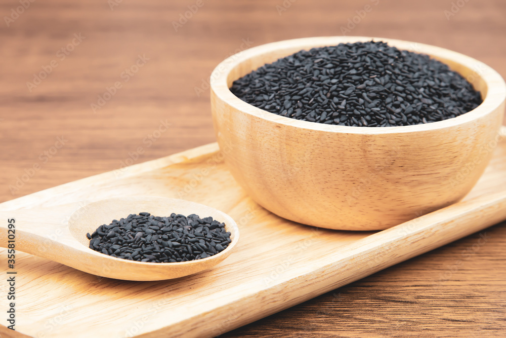 Black sesame seeds in a wooden spoon. Black sesame seeds in a wooden spoon.