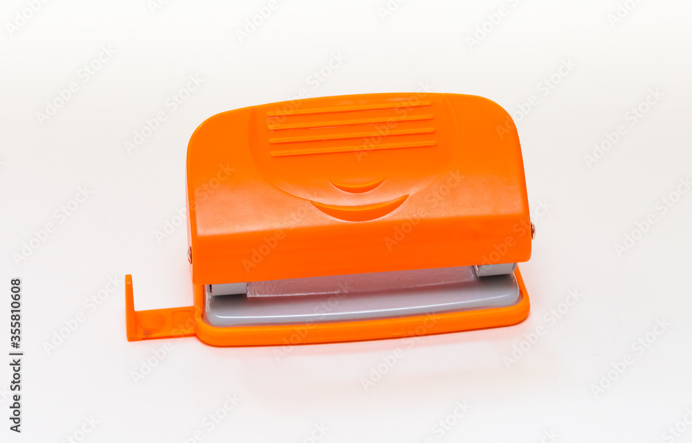 Orange and gray hole punch on a white background Orange and gray hole punch on a white background