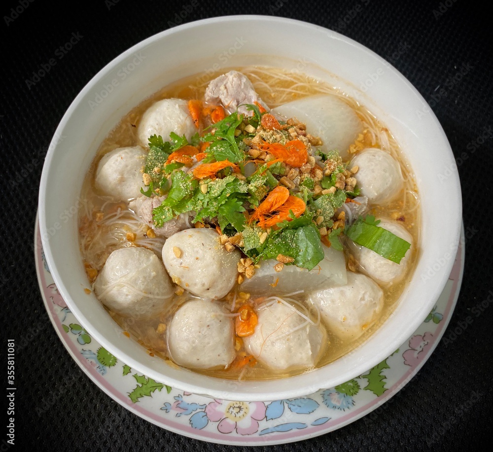 Noodle with pork ball in white bowl.