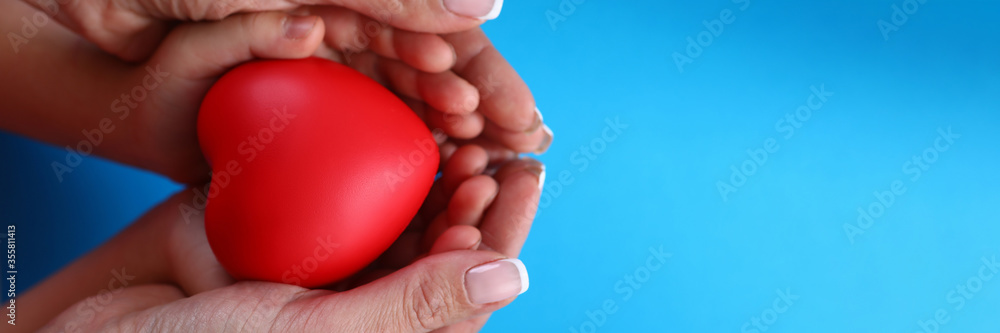 Close-up in female palms childrens hands and heart. Timely diagnosis facilitates treatment. Prevention cardiovascular diseases in family. Healthier heart mother and baby. Healthy heart protection Close-up in female palms childrens hands and heart. Timely diagnosis facilitates treatment. Prevention cardiovascular diseases in family. Healthier heart mother and baby. Healthy heart protection