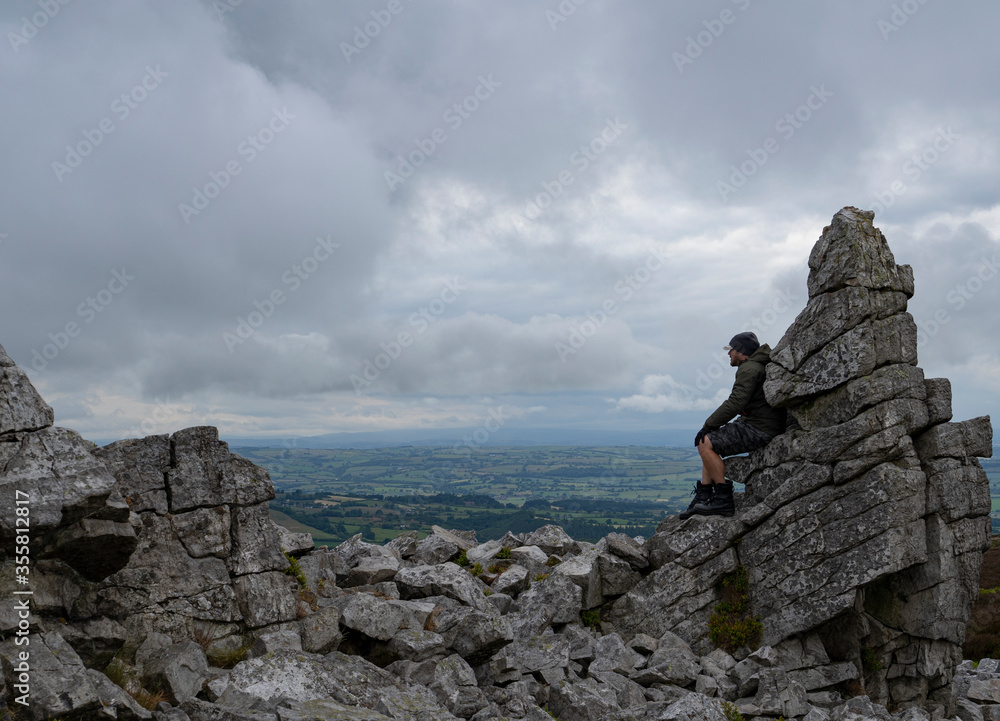 A man sitting on rocks at Stiperstones in Shropshire UK