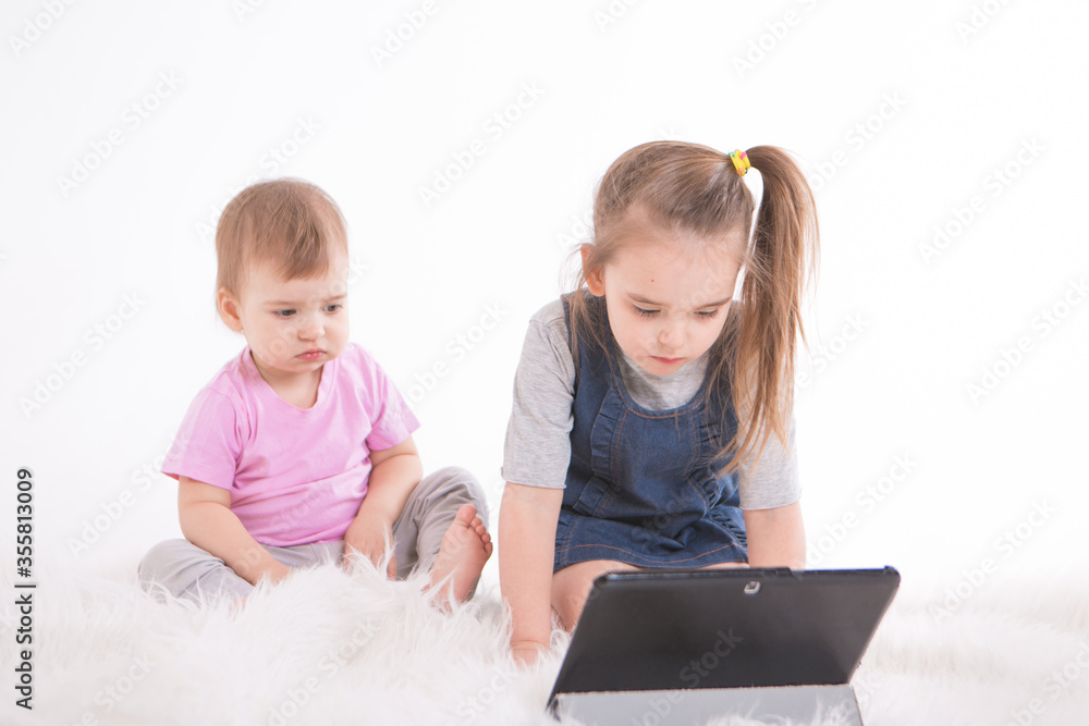 the kids are watching cartoons on the tablet. Home schooling for girls during quarantine the kids are watching cartoons on the tablet. Home schooling for girls during quarantine