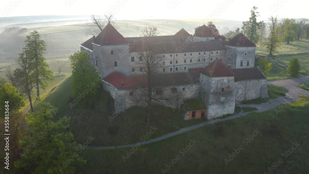Aerial view of Svirzh castle near Lviv, Ukraine at dawn. Lake, morning fog and surrounding landscape at sunrise. Aerial view of Svirzh castle near Lviv, Ukraine at dawn. Lake, morning fog and surrounding landscape at sunrise.