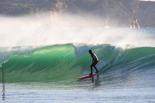 Surfing in Japan, man riding a surfboard in the pacific ocean near Tokyo photo