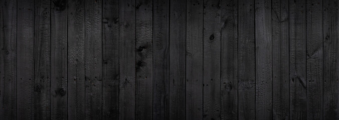 Black wood texture background coming from natural tree. The wooden panel has a beautiful dark pattern that is empty.