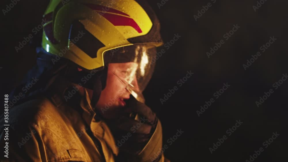 Portrait shot of a fireman in action speaking on the walkie talkie. Fire reflection on the helmet. Copy space Portrait shot of a fireman in action speaking on the walkie talkie. Fire reflection on the helmet. Copy space