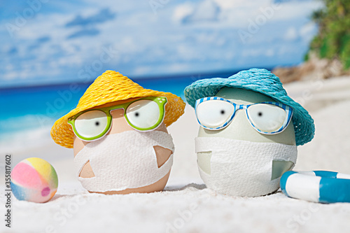 Easter eggs with faces mask at beach. Travel concept. Protection from corona virus
