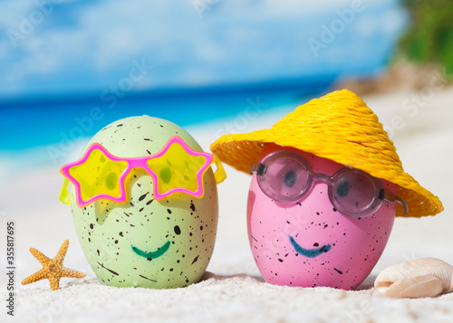 Easter eggs with happy faces at beach. Travel concept.