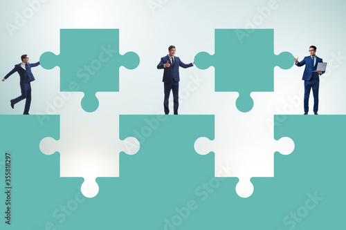 Businessman in teamwork concept with jigsaw puzzle