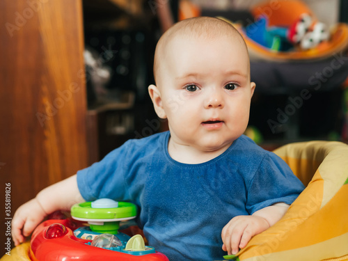 portrait of a cute Caucasian baby boy in a Walker