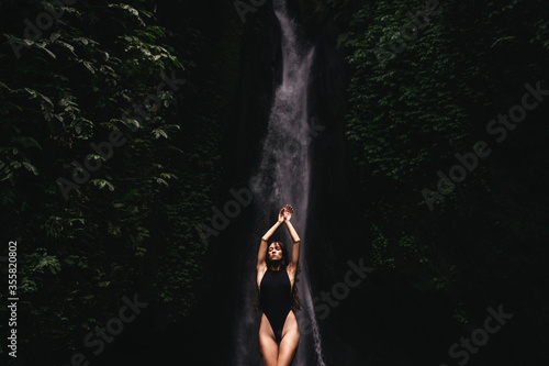young woman backpacker looking at the waterfall in jungles. Ecotourism concept image travel girl