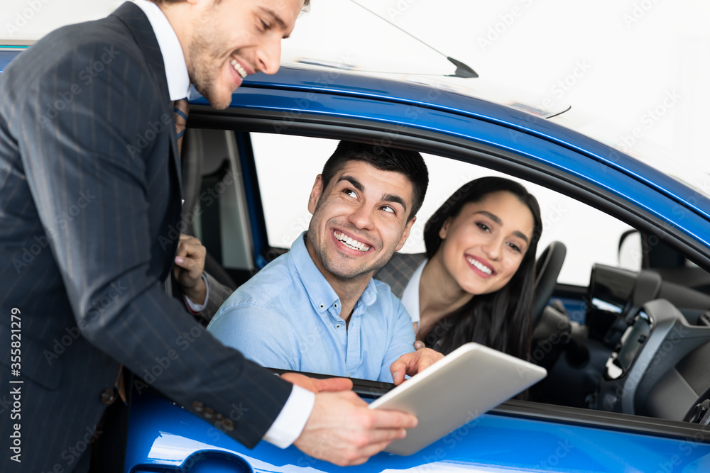 Happy Couple Buying Car Talking With Salesman Sitting In Car Happy Couple Buying Car Talking With Salesman Sitting In Car