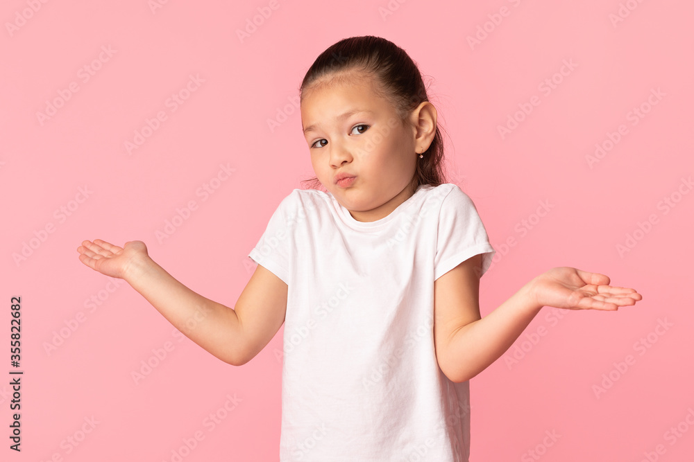 Confused puzzled asian girl shrugging at studio Confused puzzled asian girl shrugging at studio