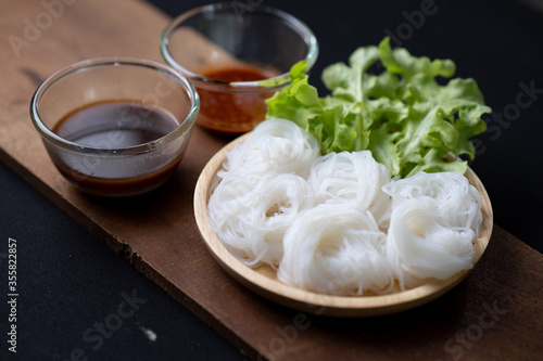 Thai Dried Rice Noodles in wooden bowl with ingredients for delivery