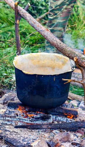 A pot of porridge on the campfire in the summer