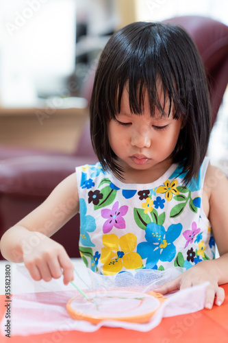 Asian girl home schooling sewing
