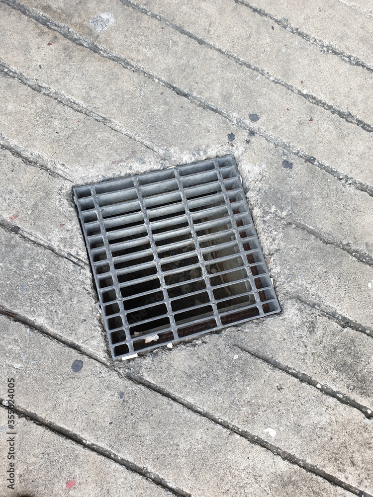 a detail of a metal drainage grid in a pavement