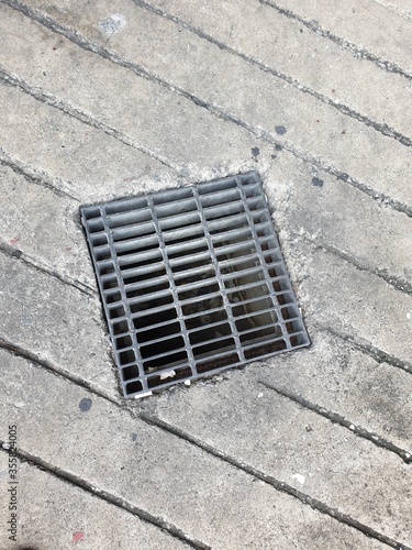 Obraz na płótnie a detail of a metal drainage grid in a pavement w salonie