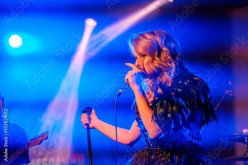 Photos Girl singer sings on stage holding microphone