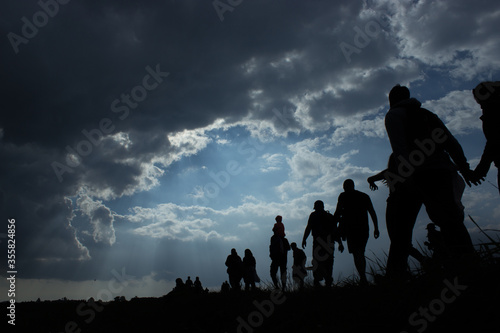 Tela Immigration of people blue sky with dark clouds