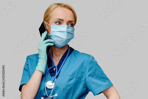 medical doctor nurse woman with stethoscope wearing protective mask and rubber or latex gloves talking on mobile cell phone