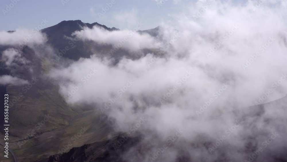 Aerial shot of beautiful clouds over rocky mountains, drone flying forward over landscape - Southwestern Iceland, Iceland Aerial shot of beautiful clouds over rocky mountains, drone flying forward over landscape - Southwestern Iceland, Iceland