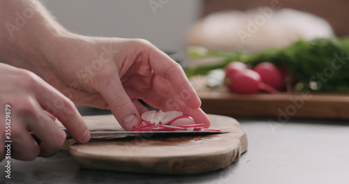 man take fresh sliced radish from olive board side view