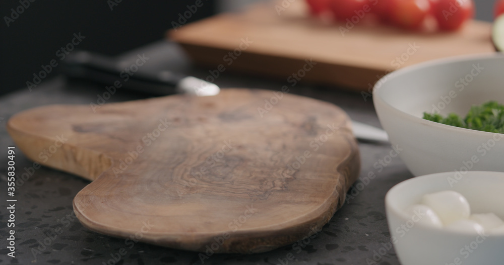 empty olive wood cutting board on terrazzo surface empty olive wood cutting board on terrazzo surface