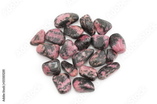 Closeup of rhodonite gemtsones or tumbled stones isolated on white background photo