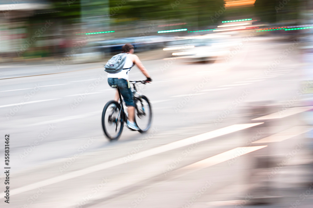 Blurry panning shot of young man speeding on a bike