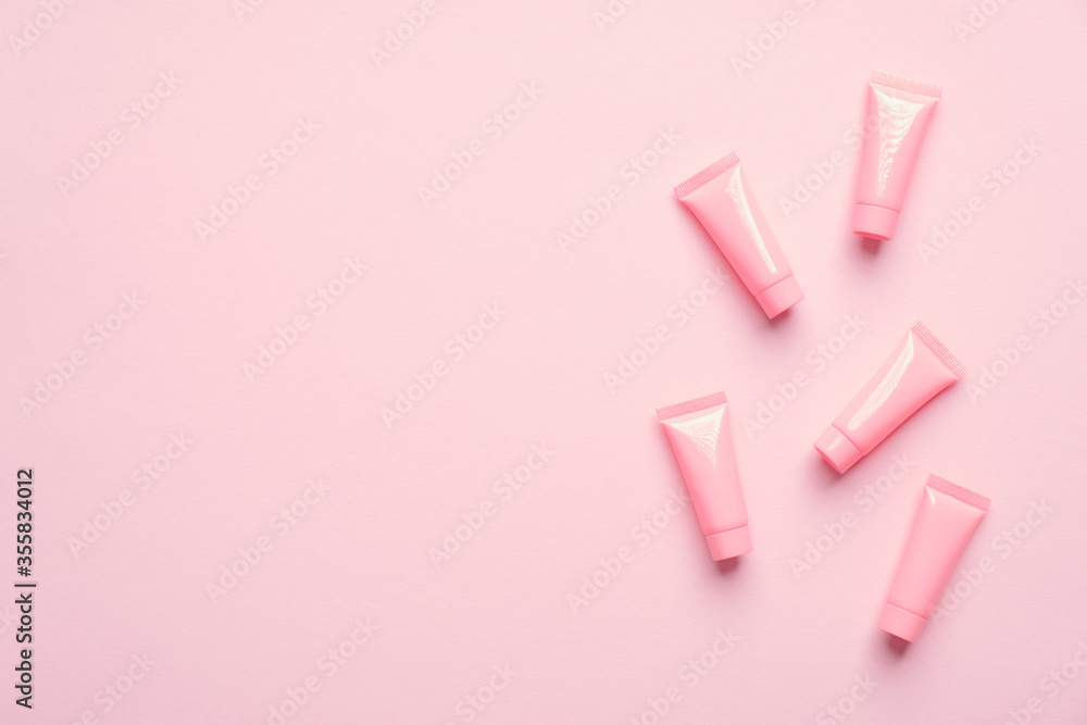 Set of blank cosmetic tubes on pink background. Beauty product packaging design, minimal style. Flat lay, top view. - obrazy, fototapety, plakaty 