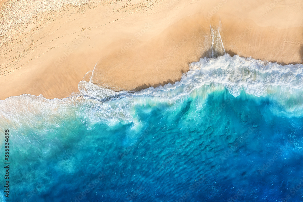 Beach and waves as a background from top view. Blue water background from drone. Summer seascape from air. Bali island, Indonesia. Travel image