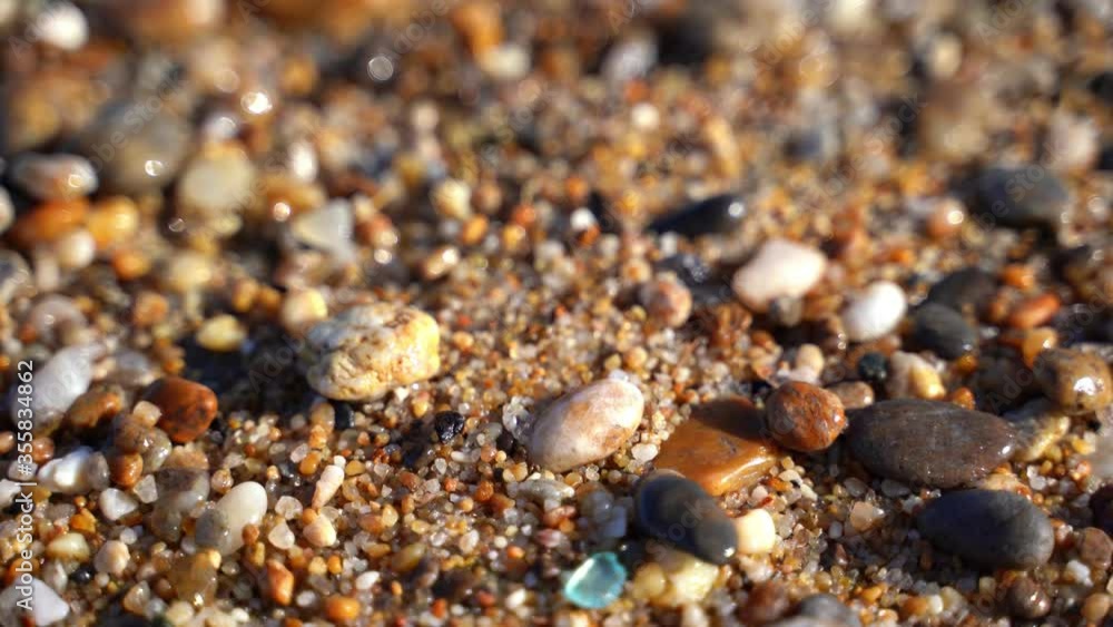 Calm tranquil waves lapping on a pebble beach, shore in day time. Wet stones on Lake Baikal. Calm tranquil waves lapping on a pebble beach, shore in day time. Wet stones on Lake Baikal.
