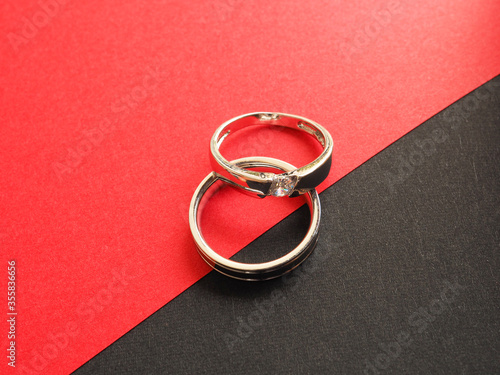 Silver two ring on red and black colored paper background. Concept for valentine's day,love,anniversary..