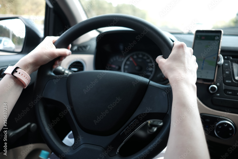 woman's hands holding steering wheel while driving a car woman's hands holding steering wheel while driving a car